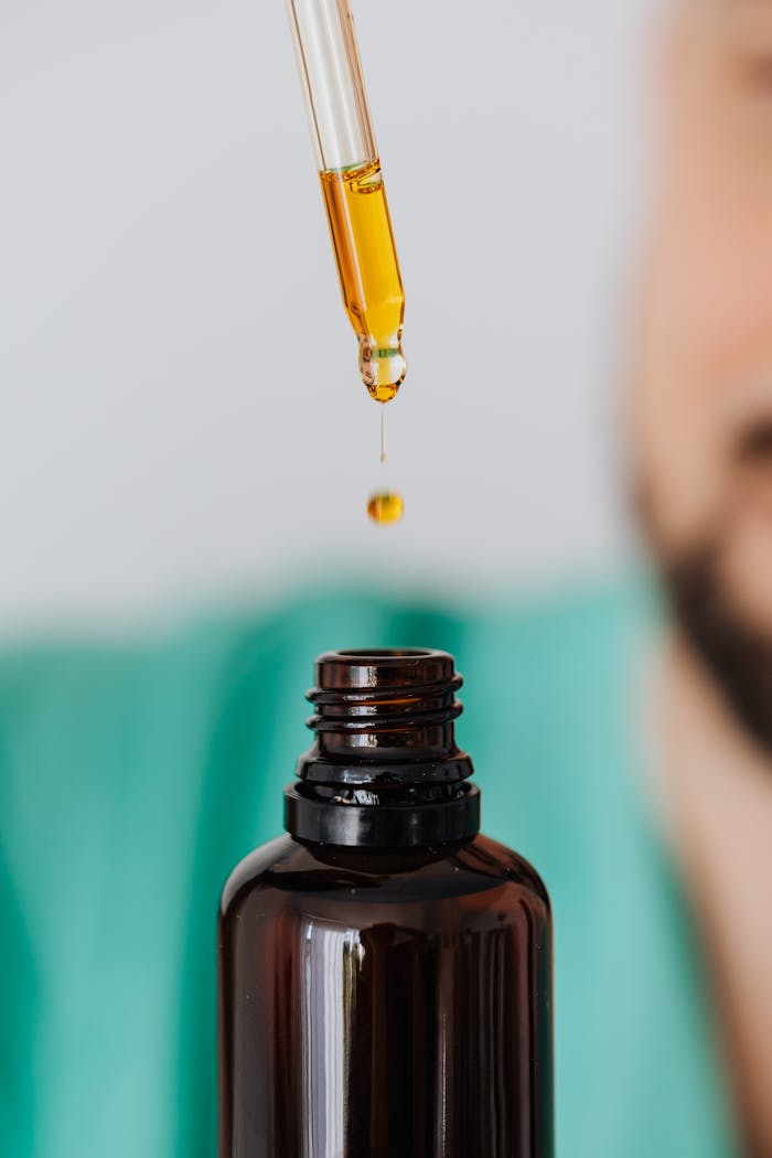 our-services-3 Detailed view of a pipette dropping essential oil into an amber glass bottle, ideal for aromatherapy visuals.