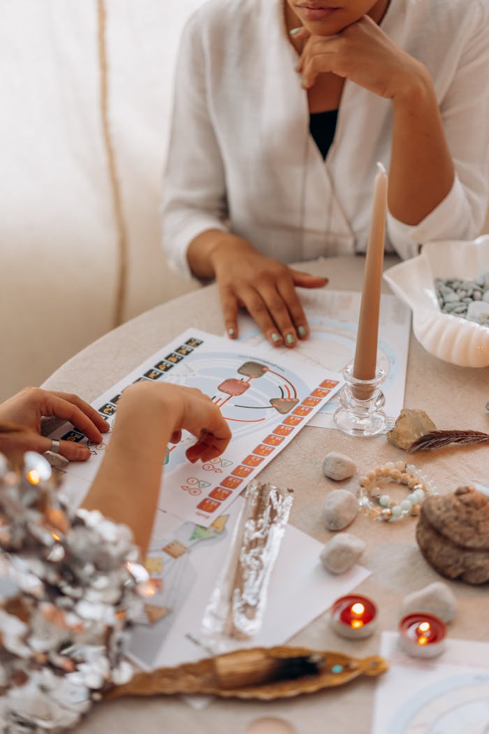 Crafting Captivating Headlines: Your awesome post title goes here Two women engaged in a spiritual practice with candles, crystals, and illustrations on a table.