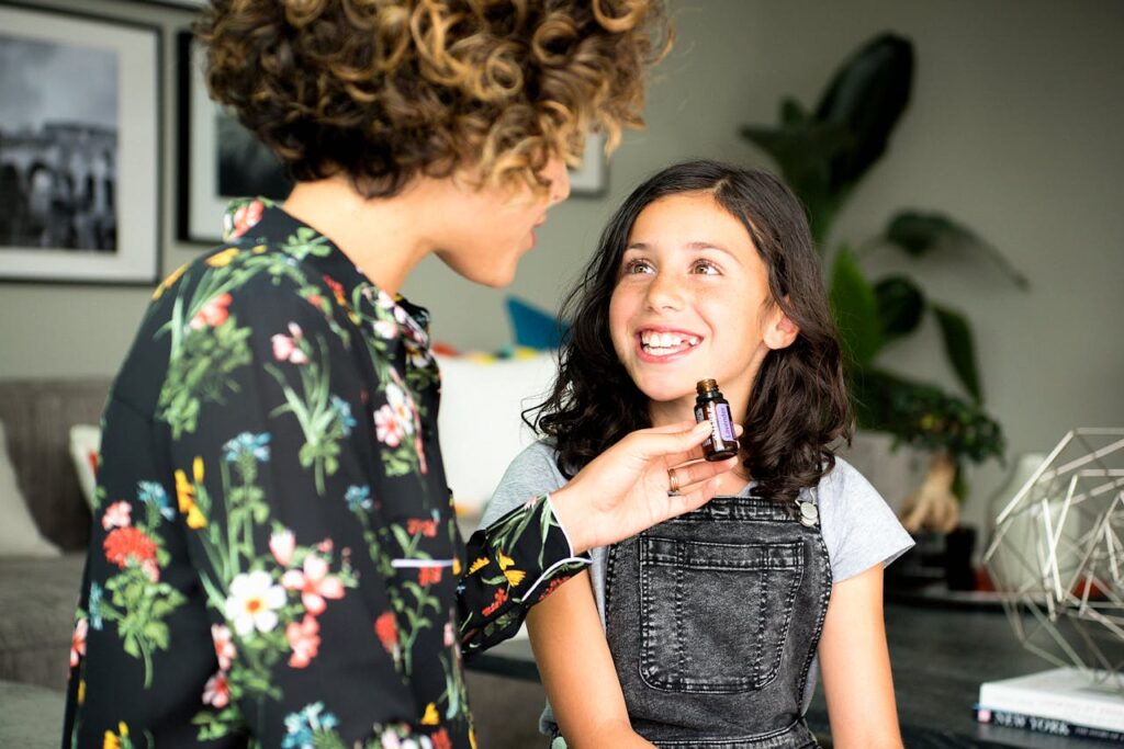 A happy mother and daughter sharing essential oils at home, enjoying a moment of wellness and bonding.